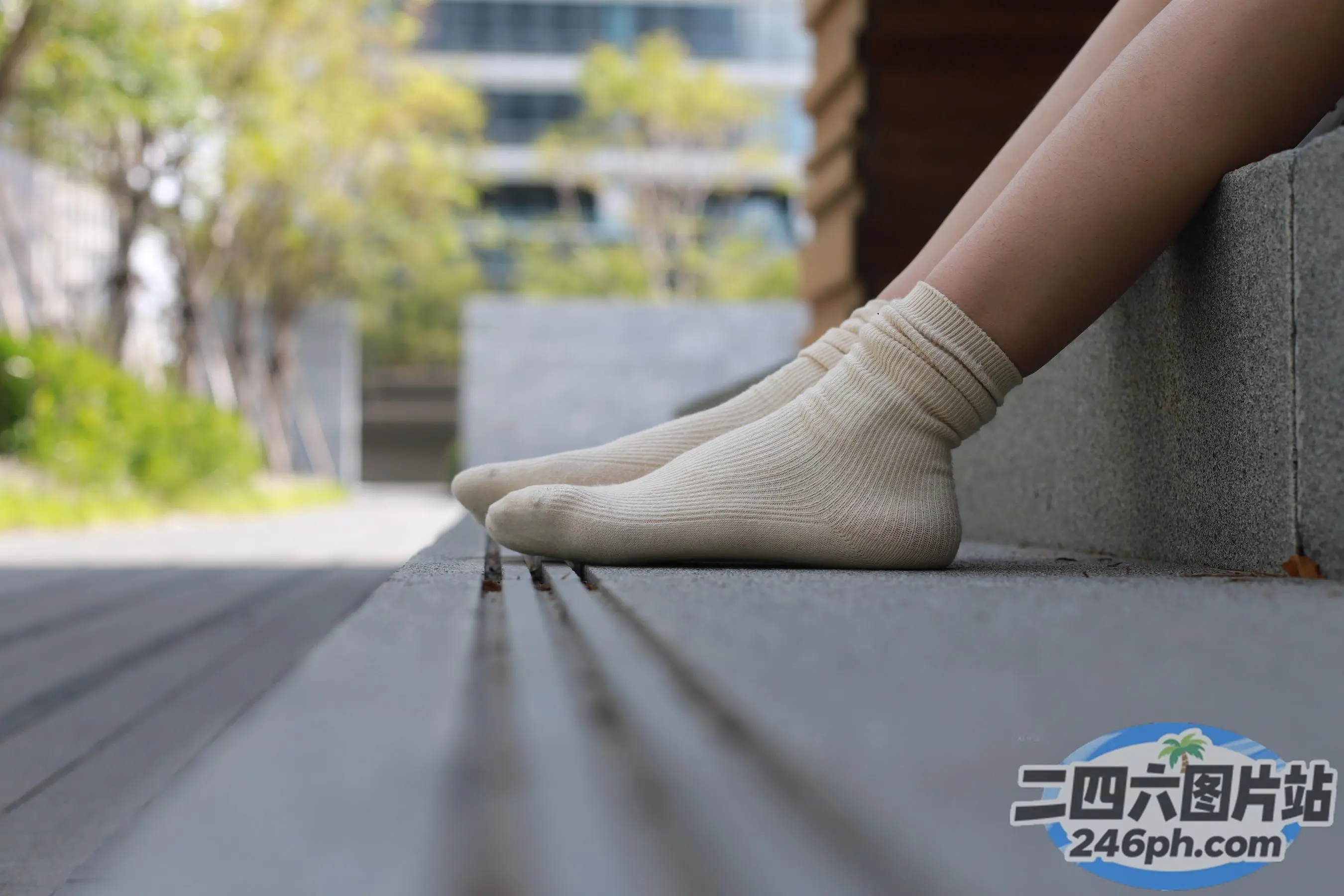 一个女人坐在城市长椅上的双腿