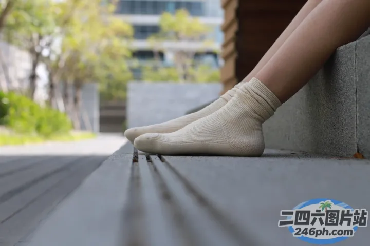 一个女人坐在城市长椅上的双腿
