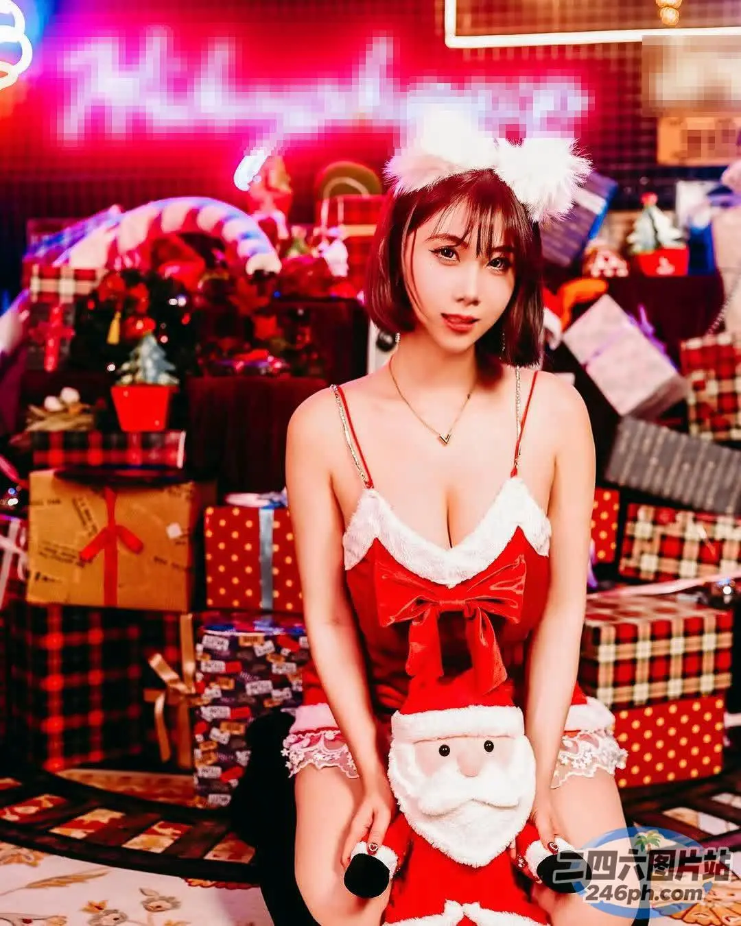 地板上坐着一个女人，手里拿着一个毛绒圣诞老人