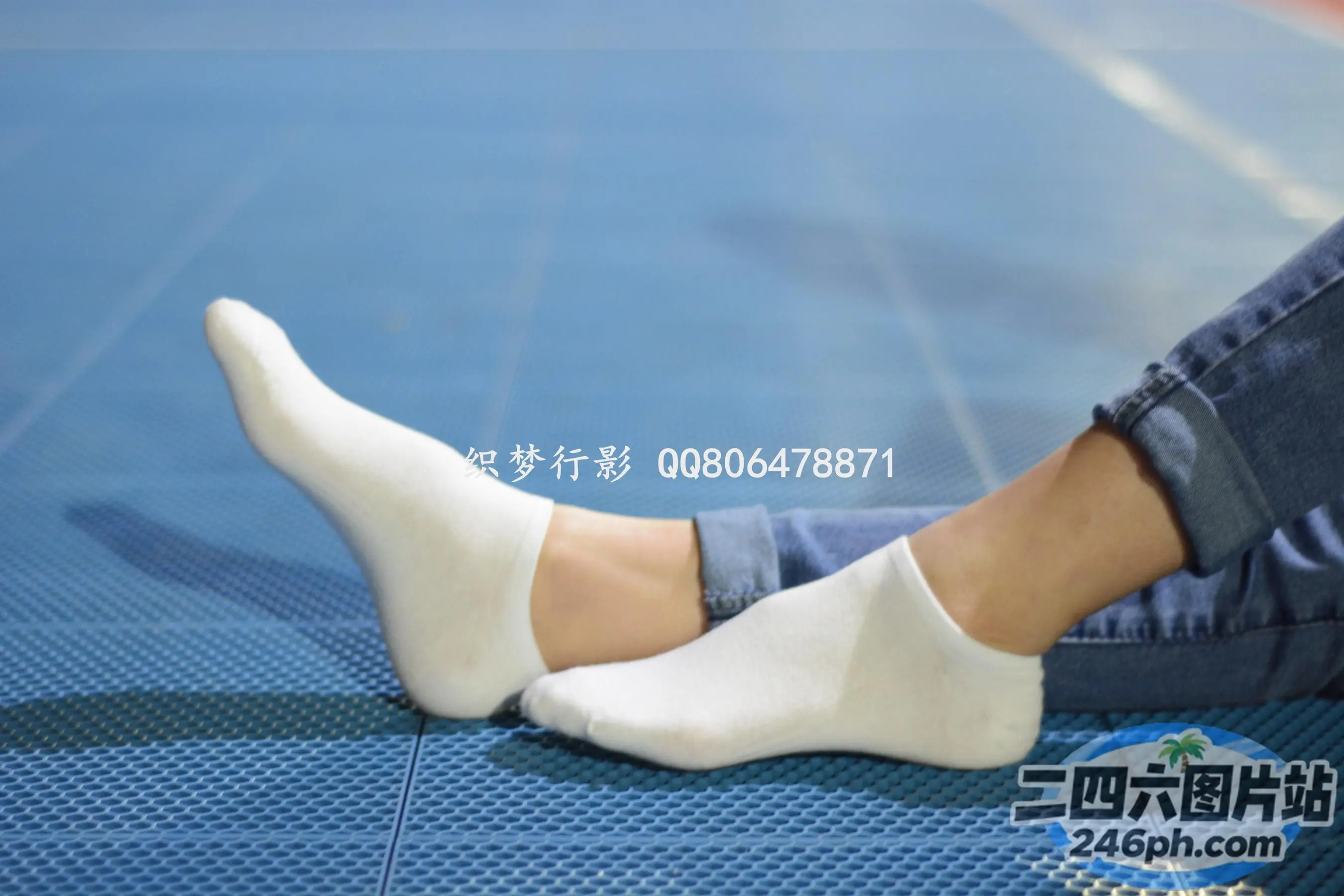 蓝色垫子上穿着白色袜子的 arafed 脚