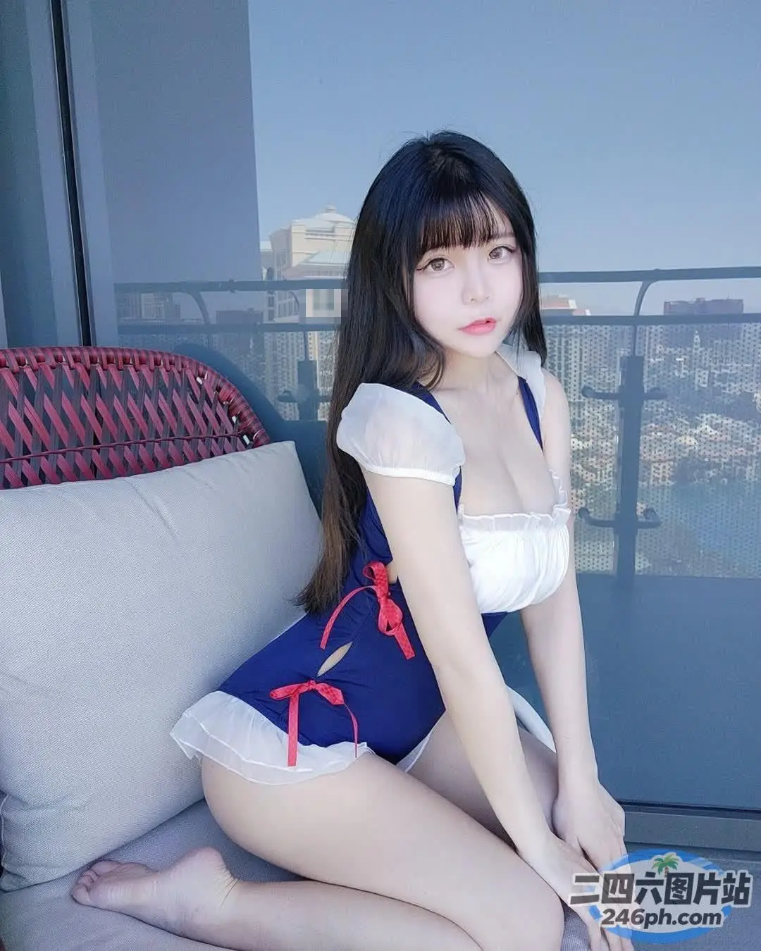 坐在沙发上穿着蓝白连衣裙的 Araffe 女子