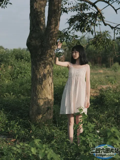 站在树旁的白裙子的阿拉菲女子
