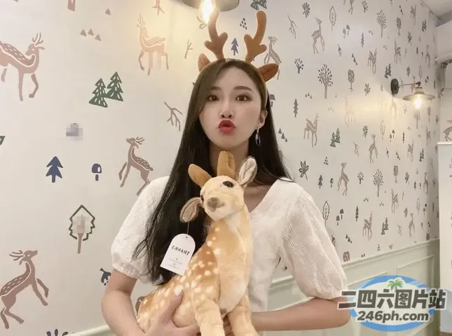 有一个女人手里拿着一只毛绒鹿