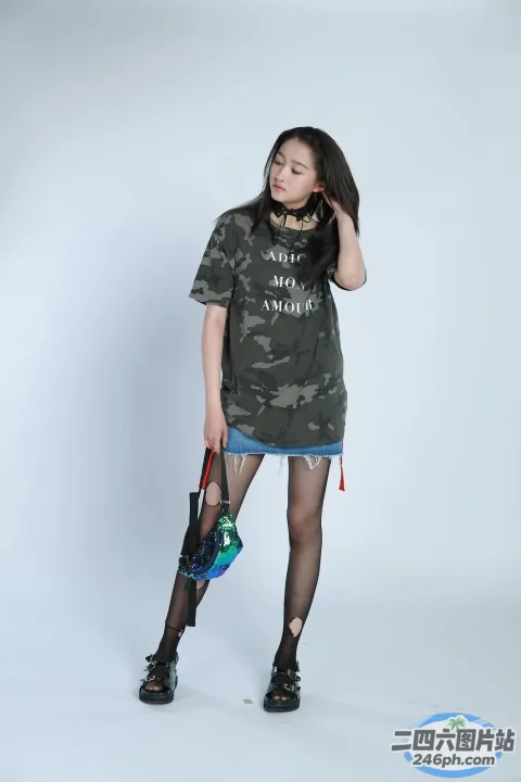 身穿迷彩衬衫和渔网袜的阿拉夫女人拿着滑板