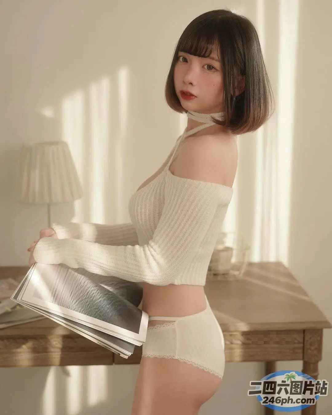 穿着白色上衣和内裤的 araffe 女人拿着一本杂志