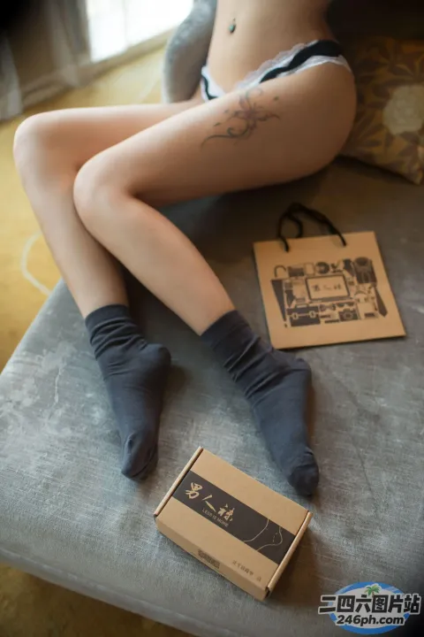 穿着内衣的 arafed 女人坐在沙发上，手里拿着一盒袜子
