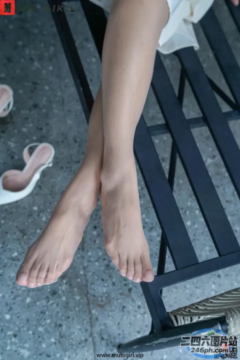 有一个女人的脚踩着鞋子坐在长凳上