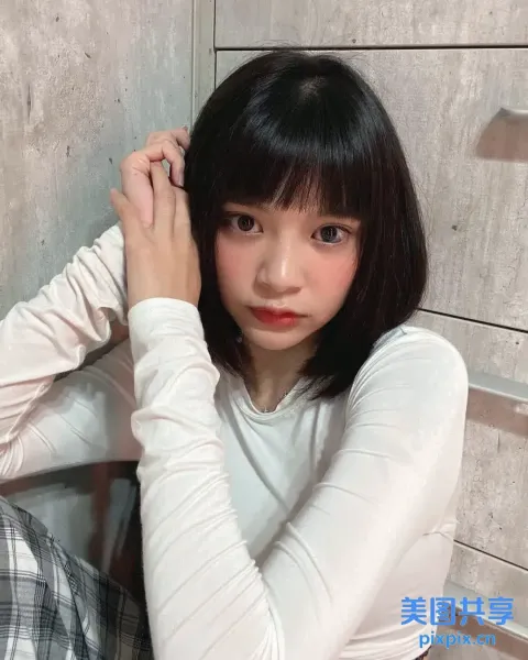 地板上坐着一个女人，手里拿着牙刷