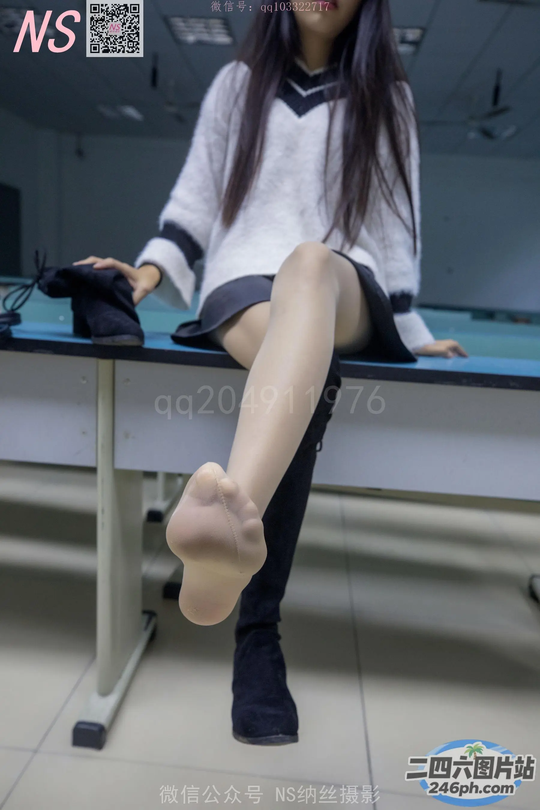 阿拉夫德女人坐在桌子上，桌上放着一台电脑和一双丝袜