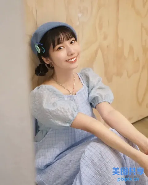 地板上坐着一个穿着蓝色连衣裙的女人