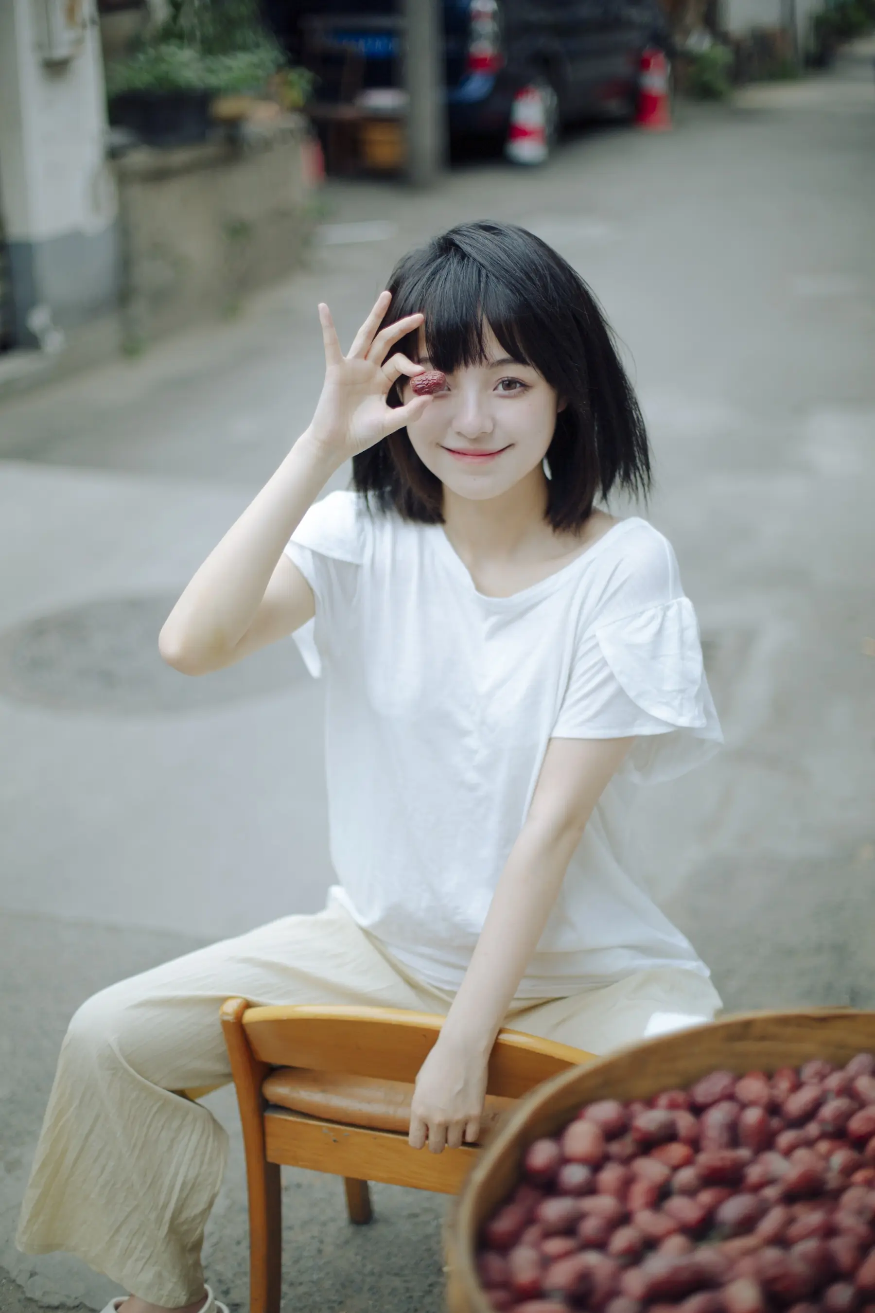 一个女人坐在椅子上，面前放着一碗水果