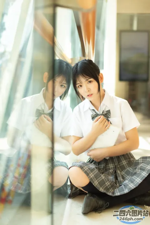 有两个女孩坐在地板上看手机