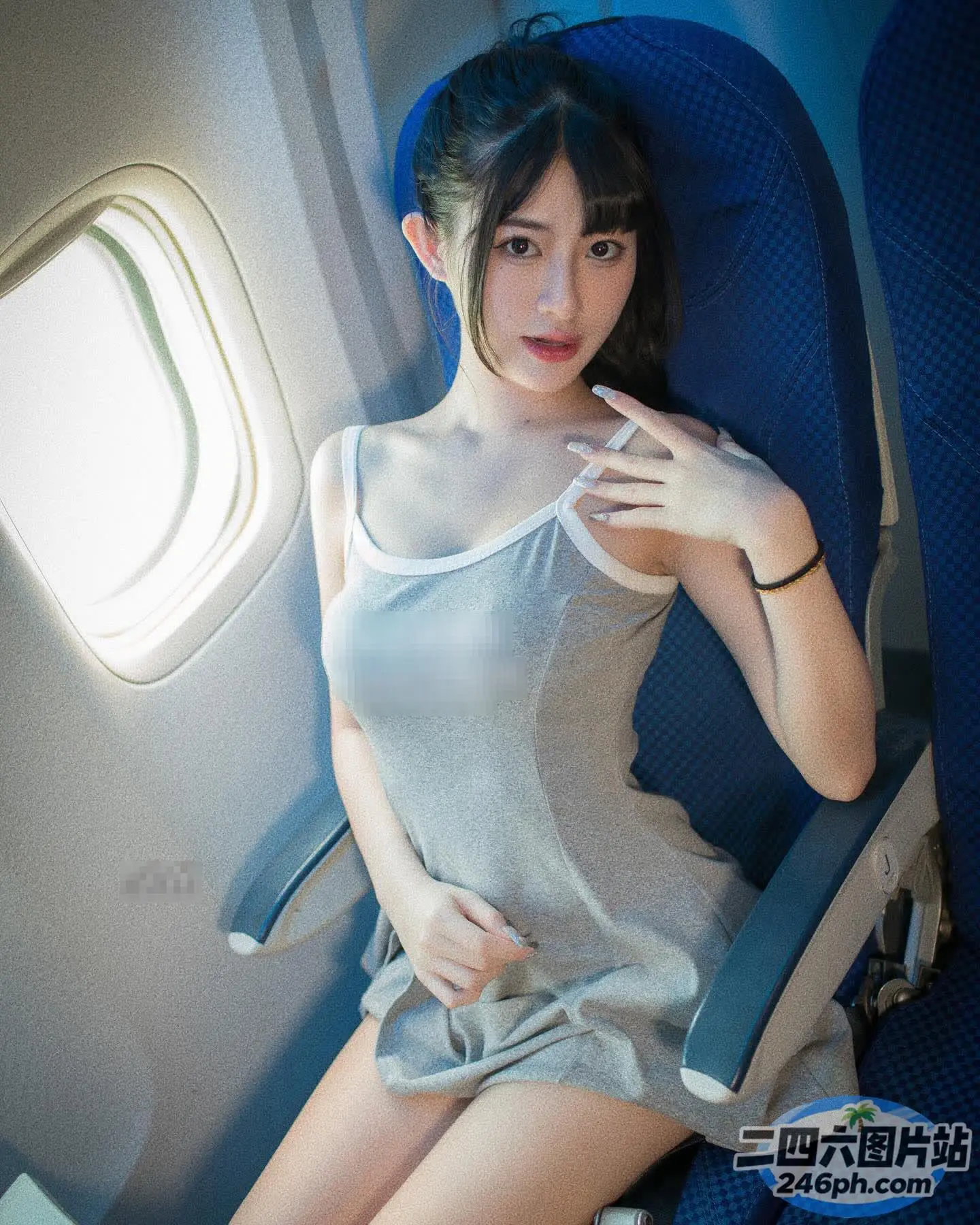 坐在飞机座位上的阿拉夫德女人，手放在胸前