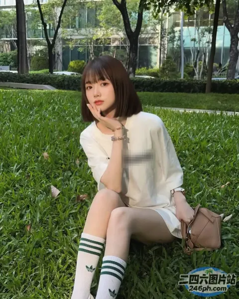 阿拉菲拿着钱包坐在公园的草地上