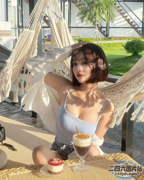 有个女人坐在吊床上喝着饮料