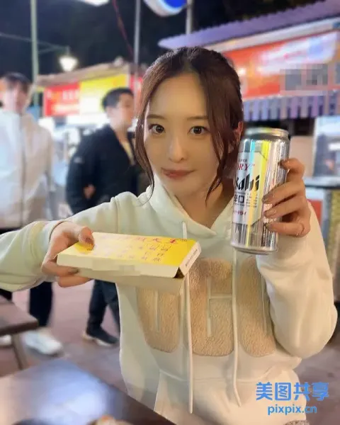 拿着一罐苏打水和一盒甜甜圈的女人