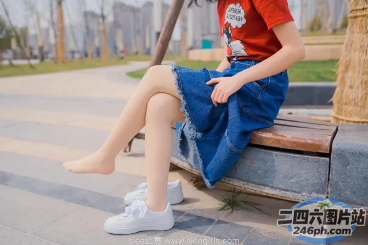 有个女人坐在长凳上，双腿交叉