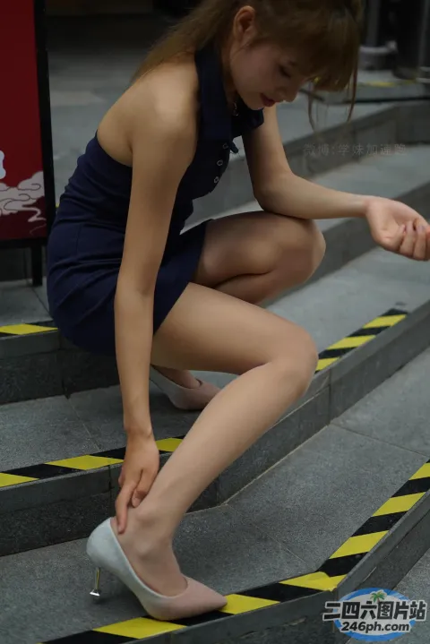 身穿蓝色连衣裙和白色高跟鞋的 araffe 女子站在楼梯上