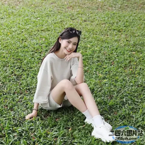 阿拉夫德女人坐在公园的草地上，手里拿着一本书
