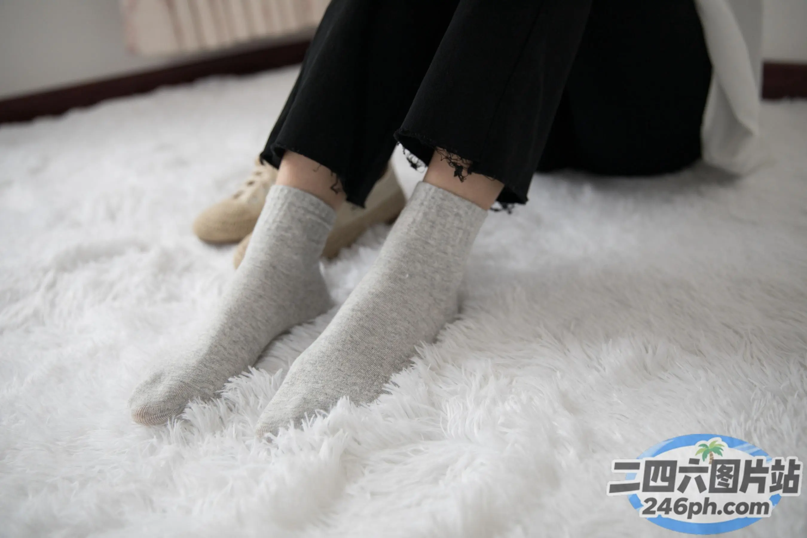 有人坐在白色地毯上，双脚抬起