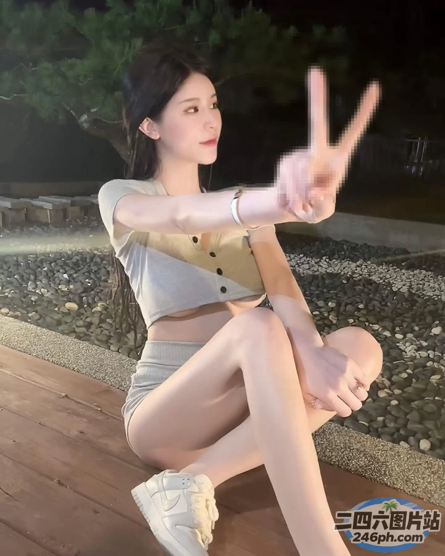 有一个女人坐在木地板上，双腿交叉
