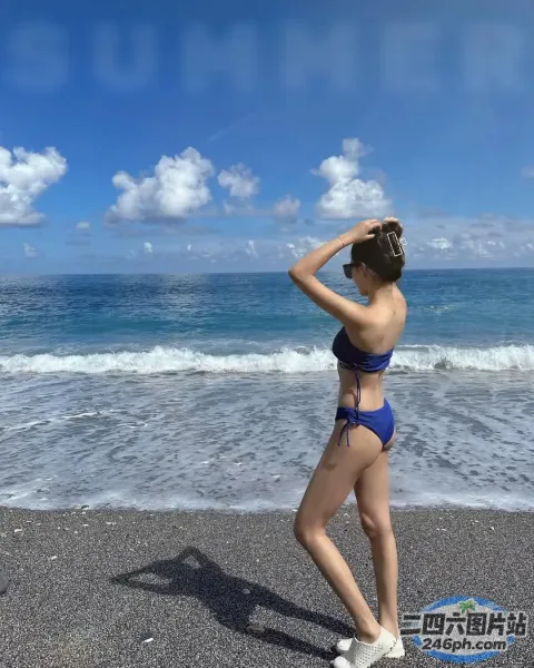 海滩上站着一个穿着蓝色比基尼的女人