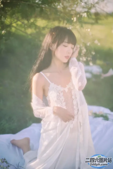 毯子上坐着一个穿着白色连衣裙的女人