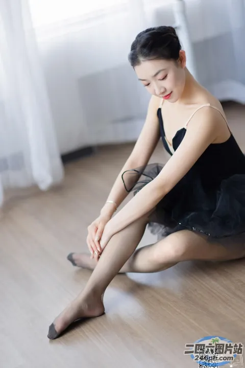 地板上坐着一个穿着黑色连衣裙的女人