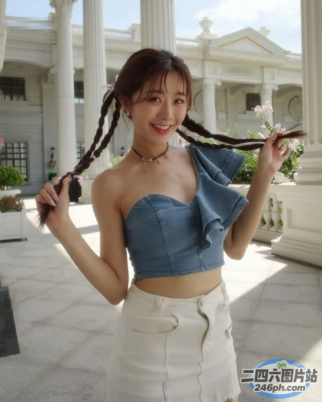 一位长发女子站在一栋白色建筑前