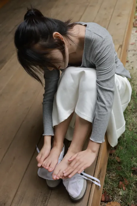 阿拉夫德女人坐在木凳上系鞋带