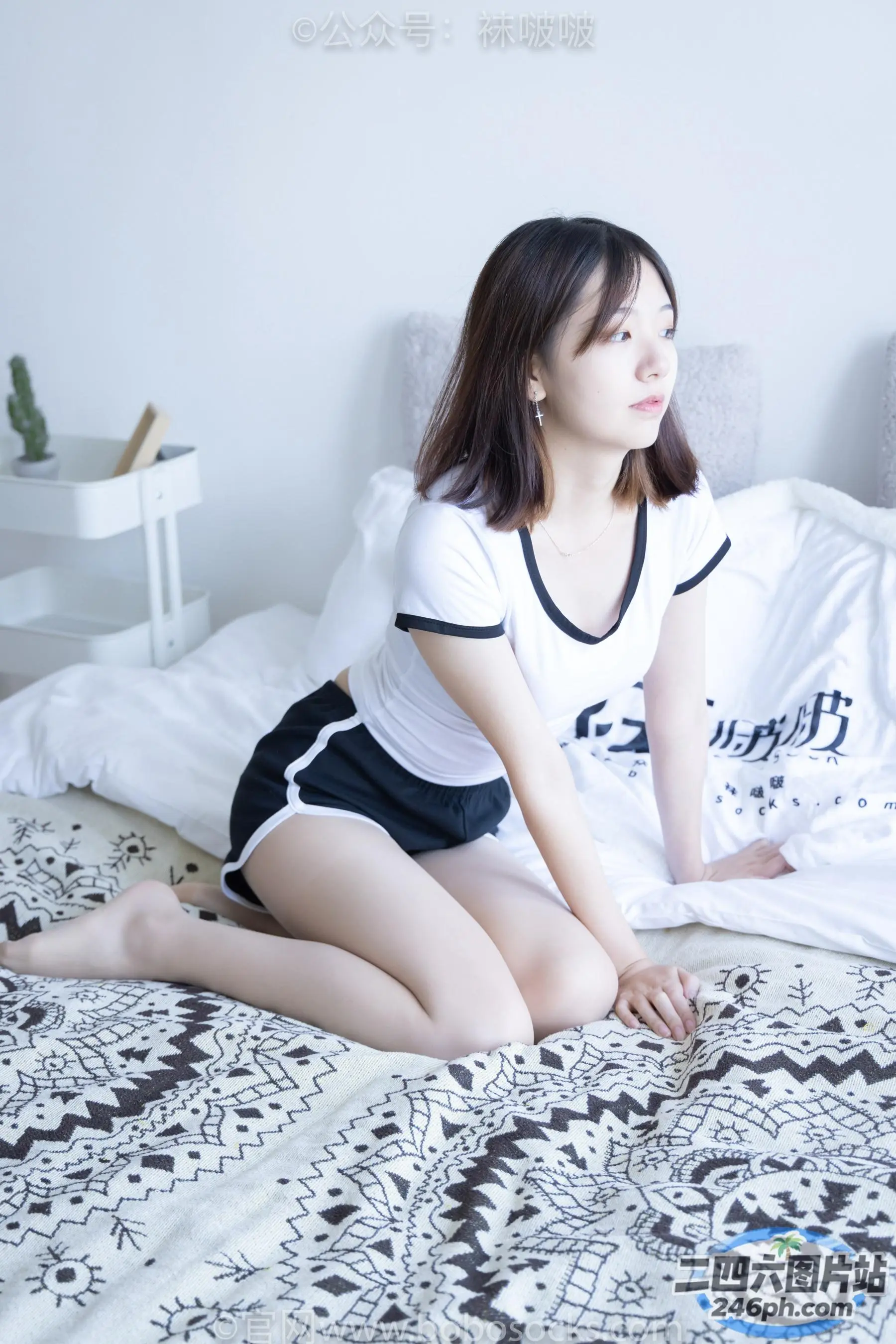 床上坐着一个穿着白衬衫的女人