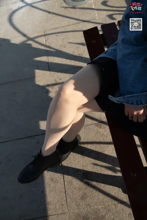 有个女人坐在长凳上，双腿交叉