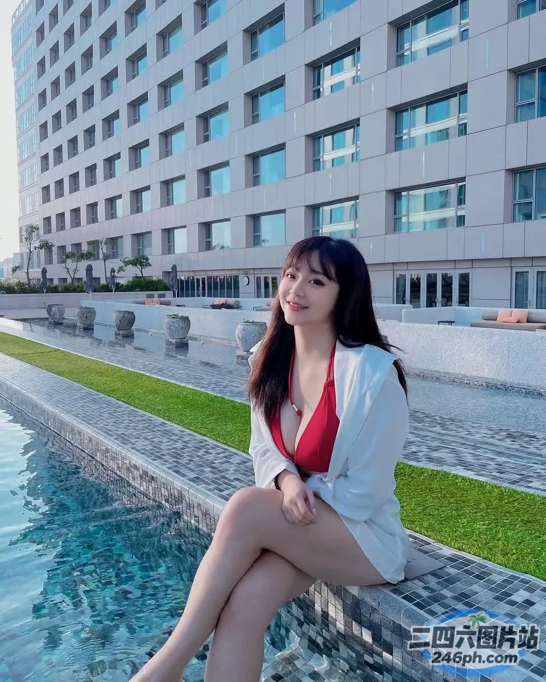 坐在泳池边壁架上的阿拉菲女人