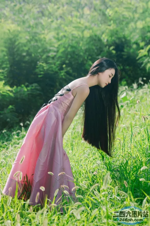 草地上穿着粉红色连衣裙的 araffe 女人