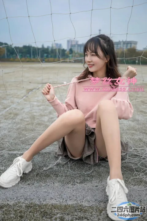 一名女子拿着网球拍坐在地上