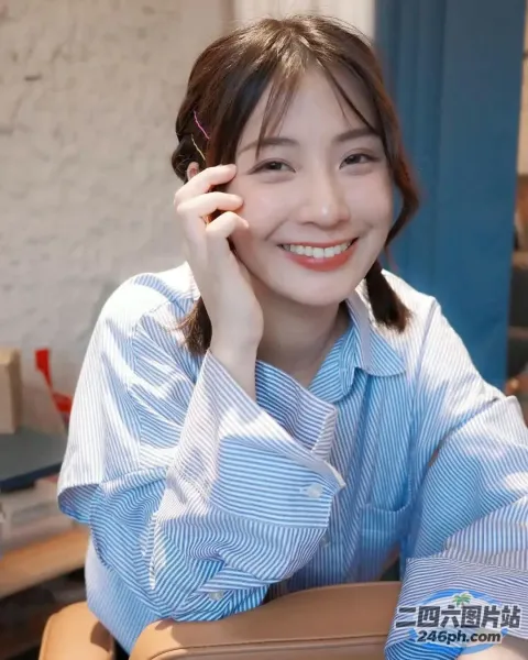 面带微笑的女人坐在桌子旁，手里拿着一个棕色的包和手机