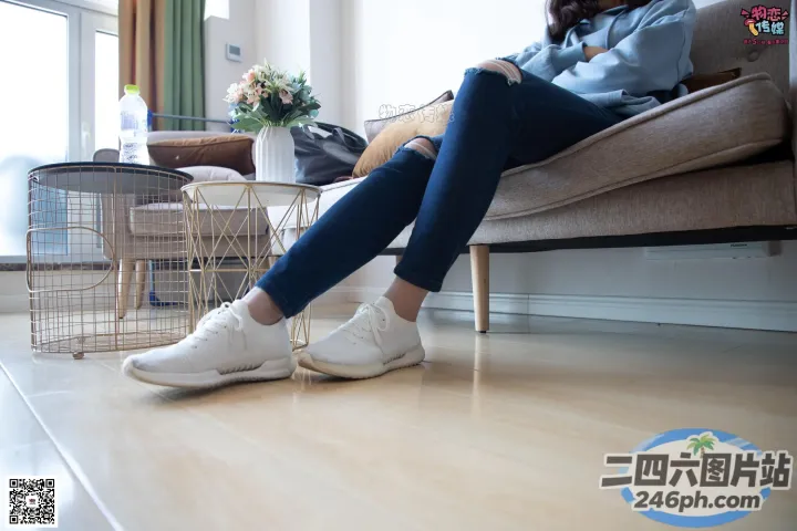 有个女人坐在沙发上，双脚着地