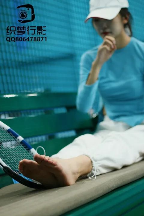 拿着网球拍坐在长凳上的阿拉菲德女人