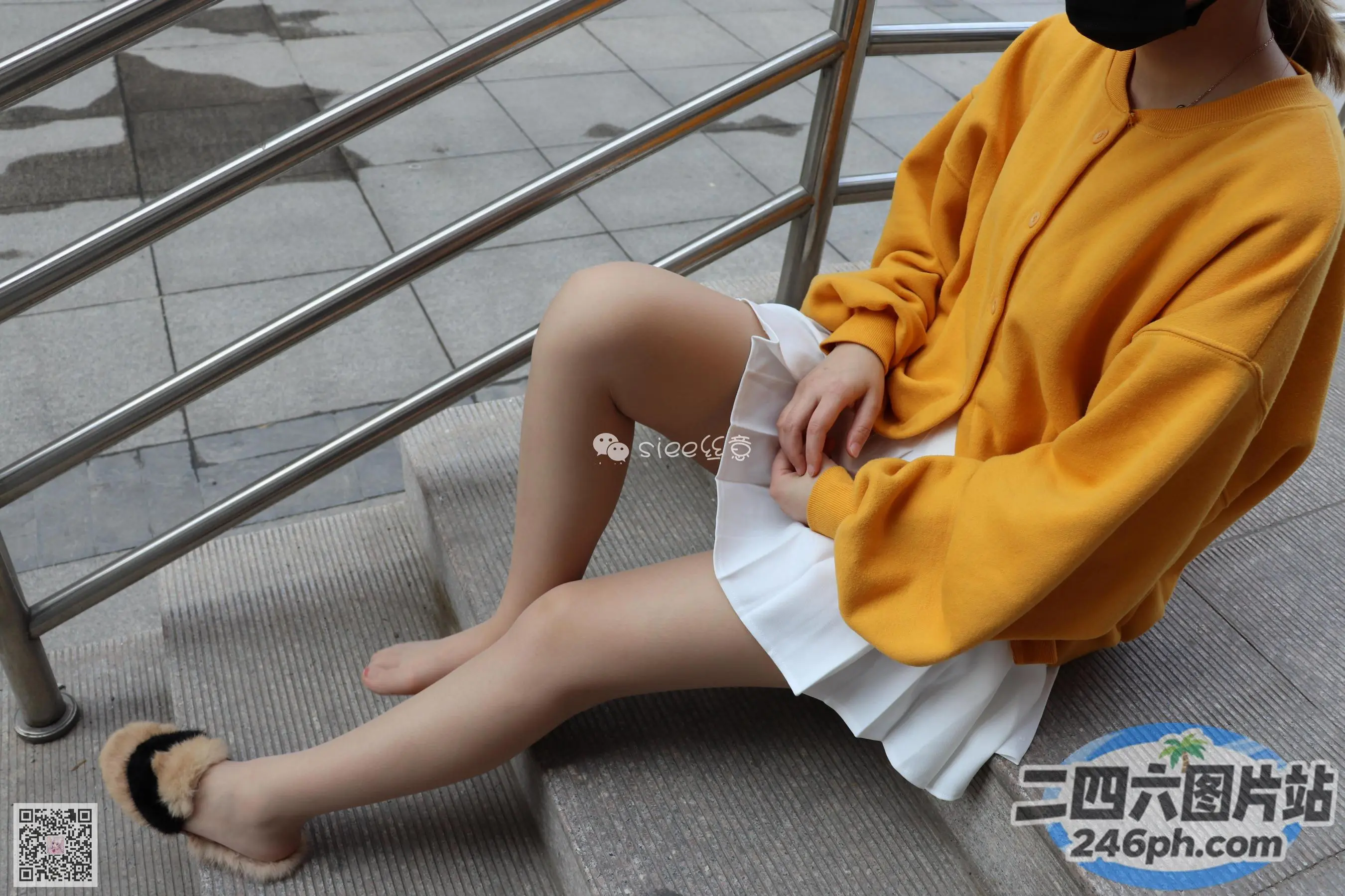 坐在台阶上的阿拉菲德女人，戴着口罩和裙子