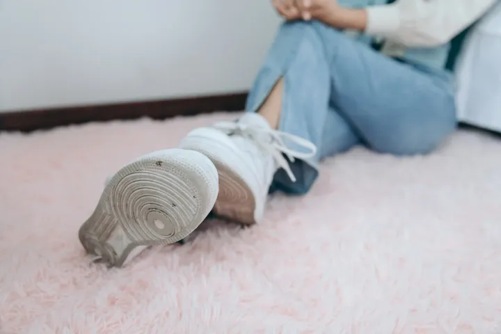 有人坐在地板上，双脚抬起