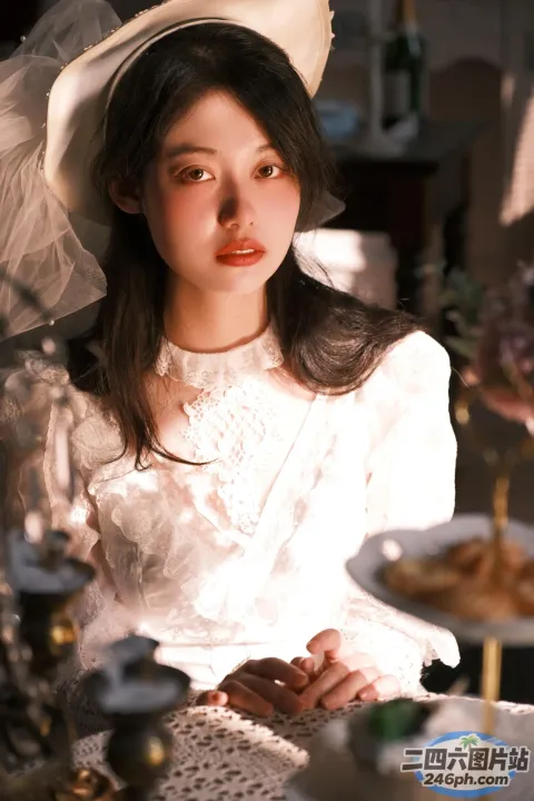 桌旁坐着一个女人，手里拿着蛋糕和帽子