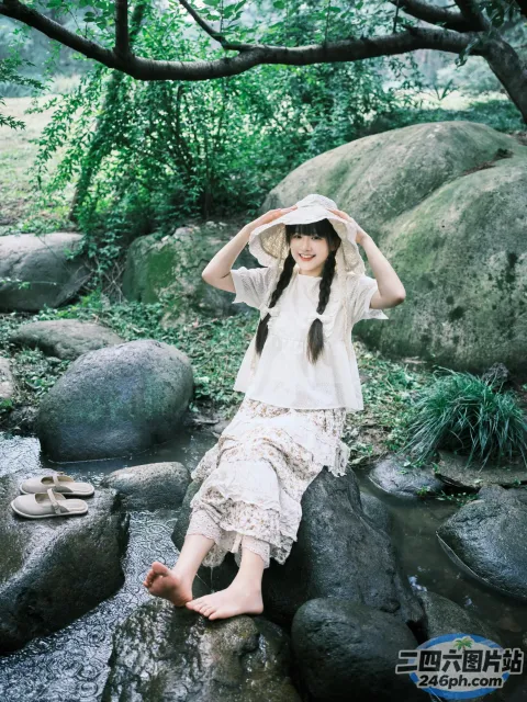 There is a woman on a rock in the water （有个女人坐在水中的一块岩石上）