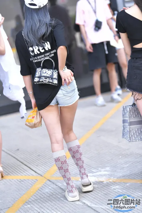 街上走着一个蓝头发、戴着帽子的女人