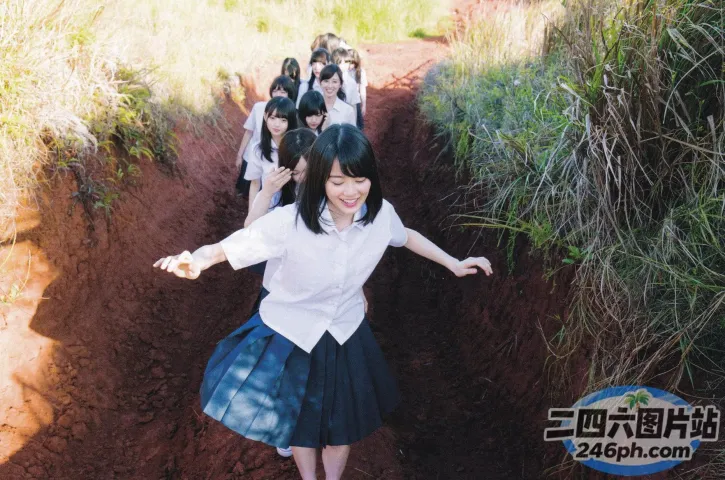 有许多女孩在草地上的一条小路上行走