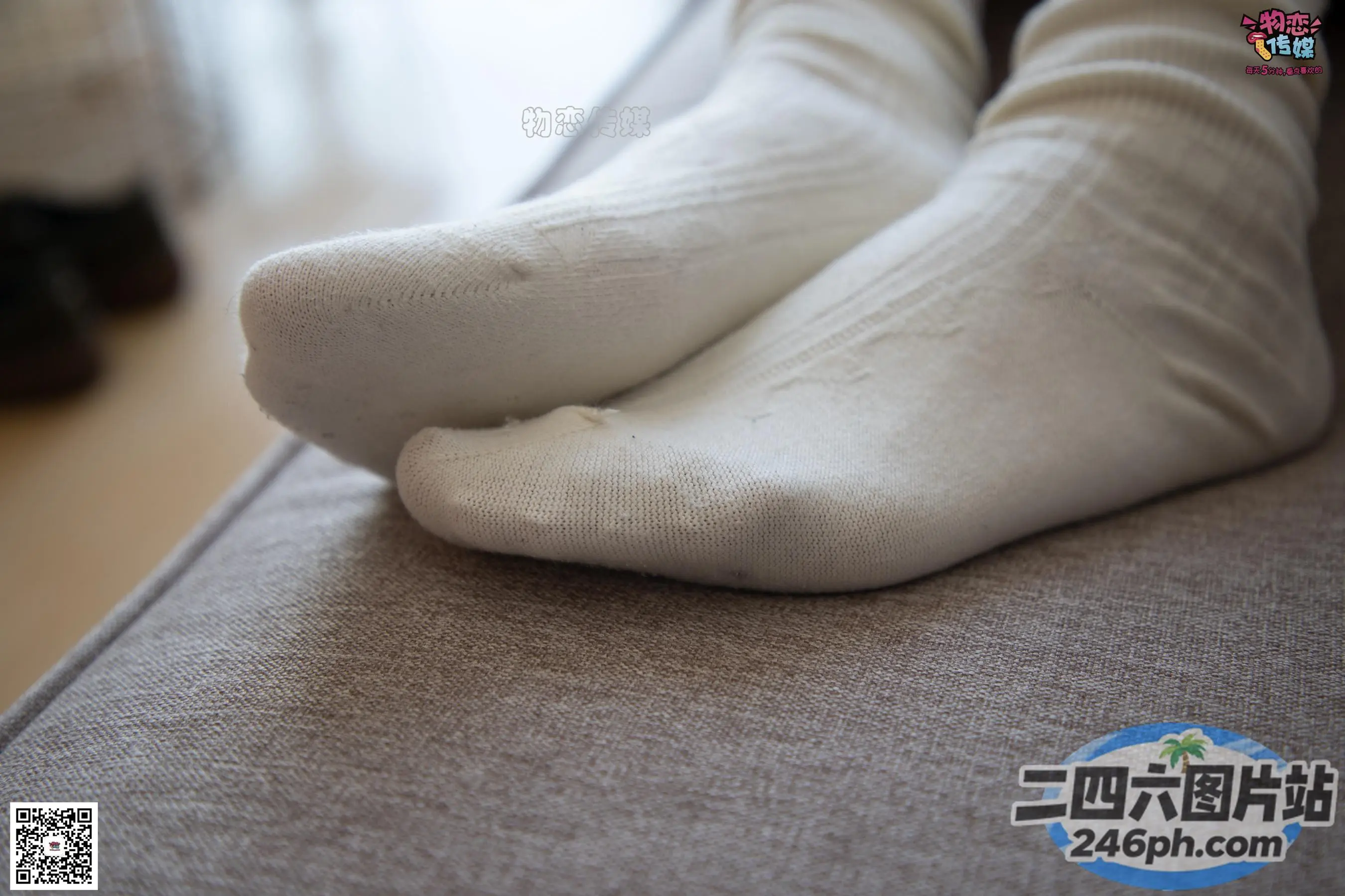 沙发上穿着白袜子的人的双脚