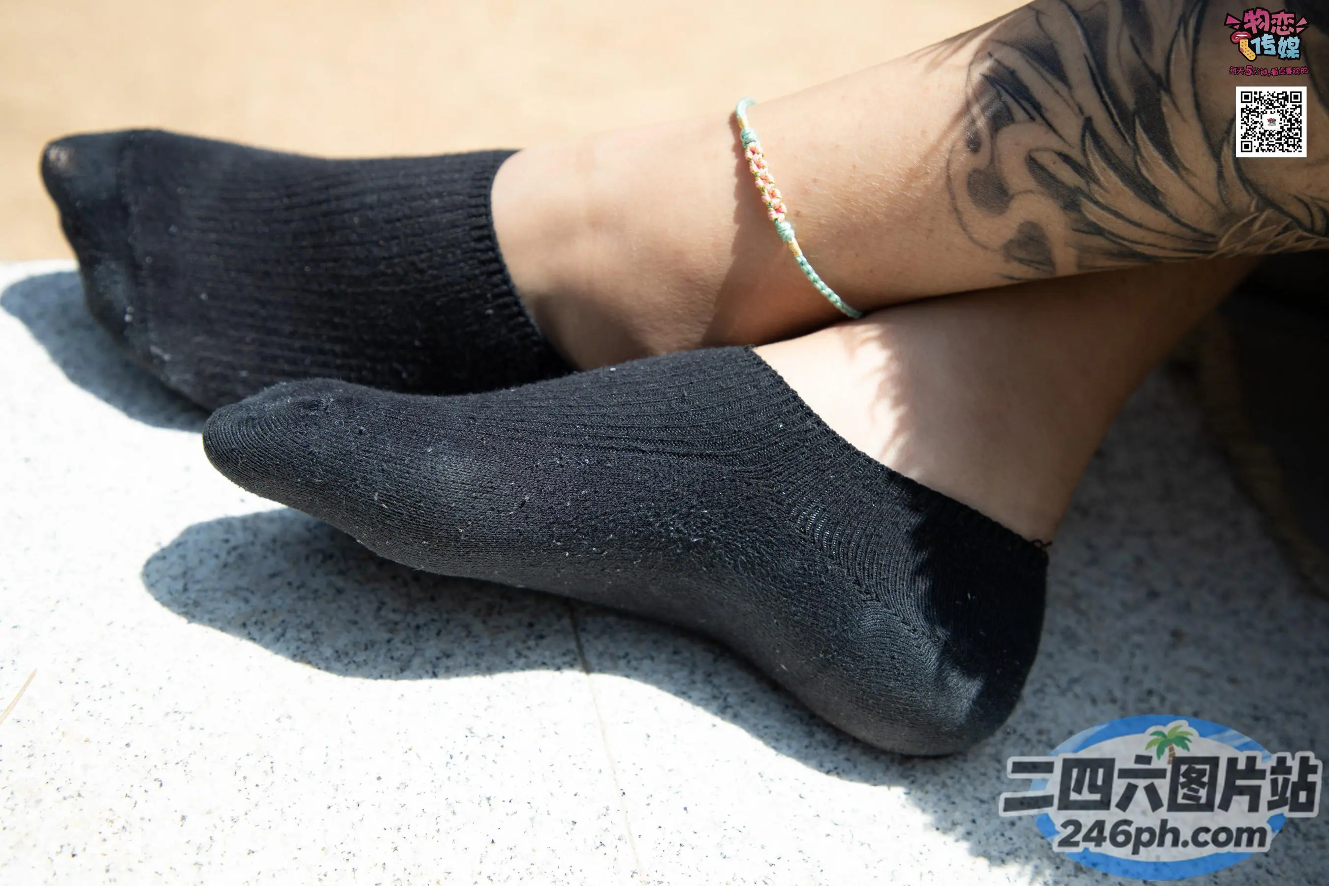 某人的手臂上有纹身，脚踝上有手镯