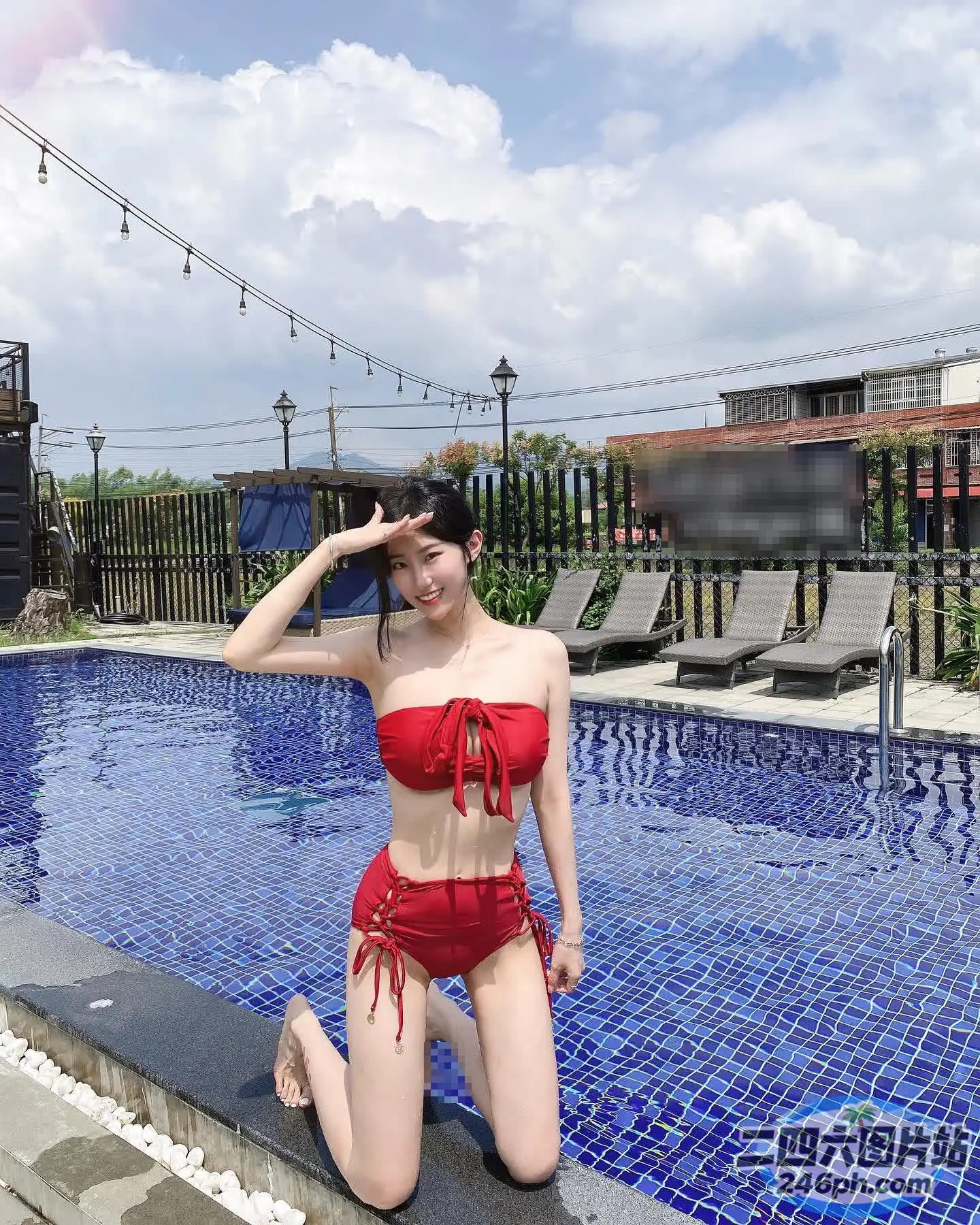 穿着红色比基尼的 arafed 女人坐在游泳池旁边的窗台上