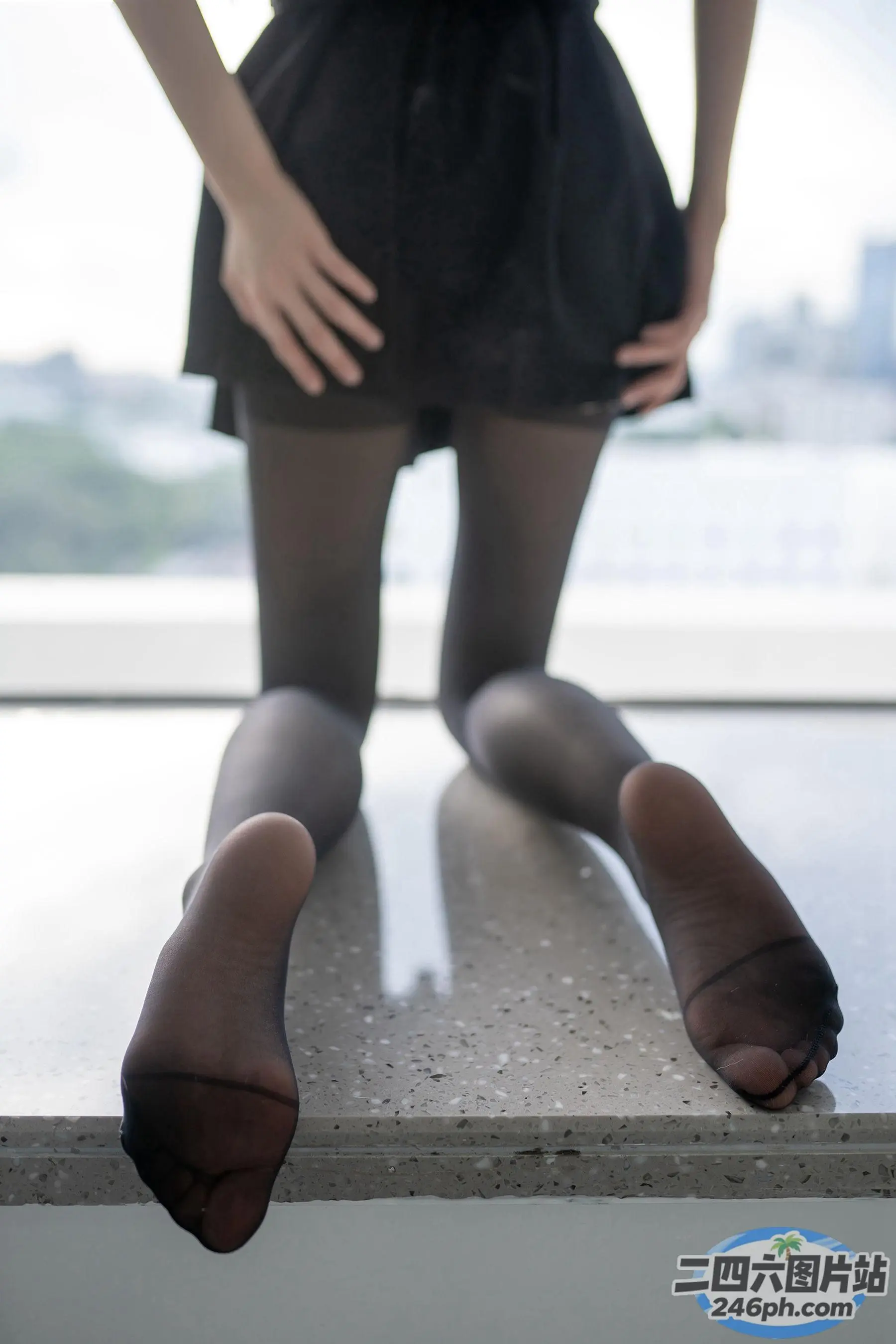 有一个女人站在窗台上，双腿交叉