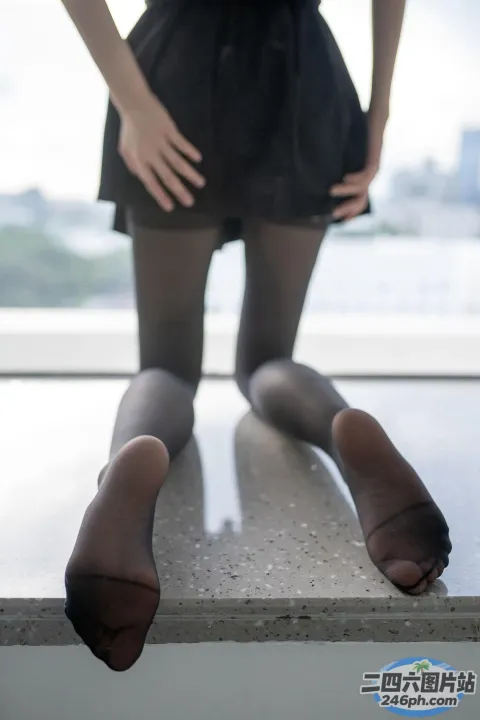 有一个女人站在窗台上，双腿交叉