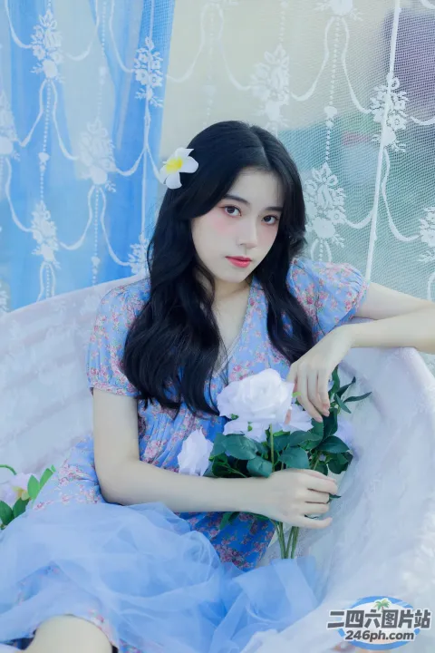 有一位女士坐在长凳上，手里拿着一束鲜花